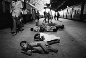 La sveglia del mattina della gang di Victoria Terminus Station lungo la banchina del binario numero sette. Bombay, India © Dario Mitidieri 1992